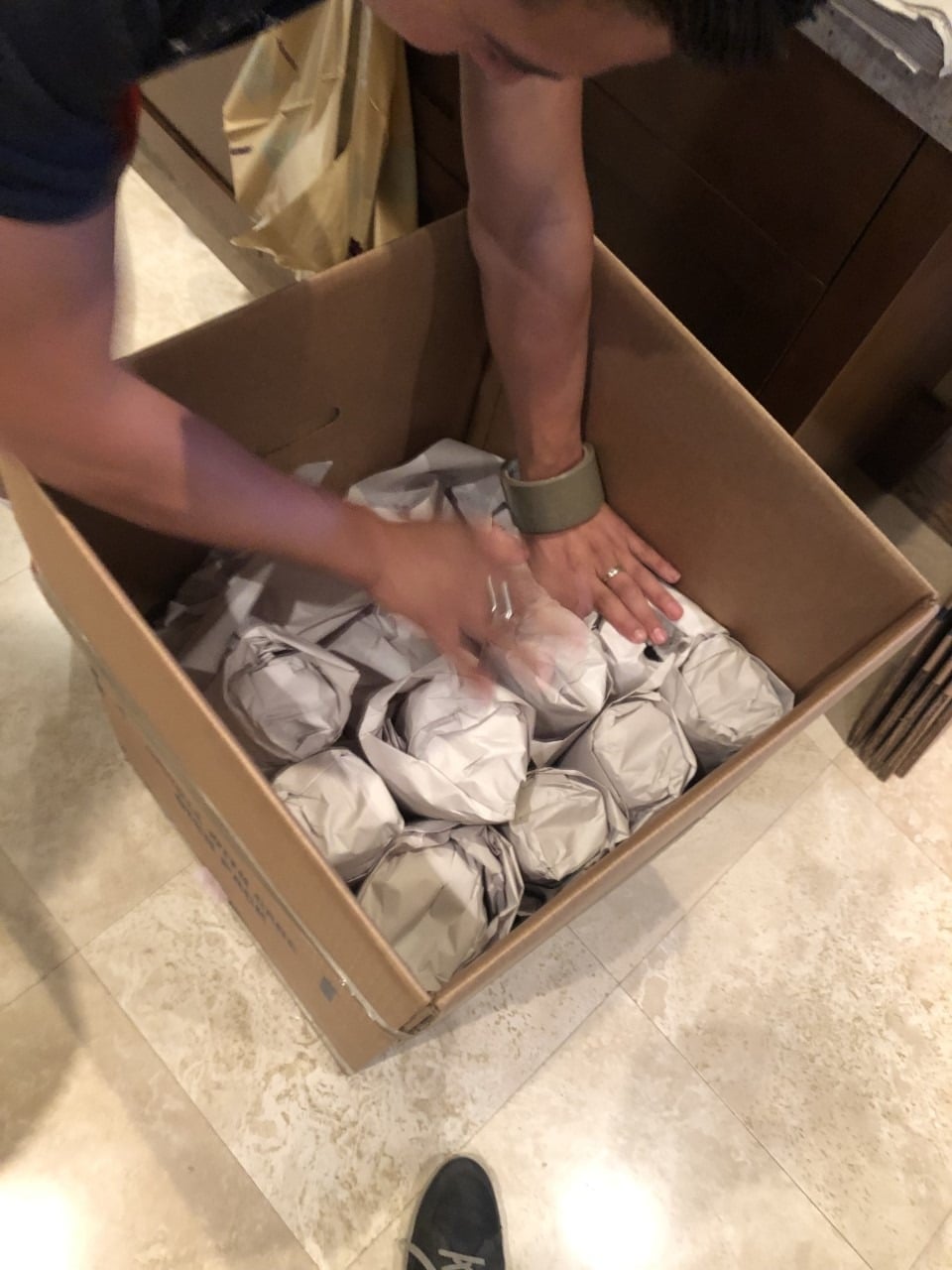 One Stop Moving packer wrapping dishes into a dish-pack box