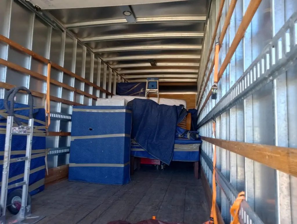 Furniture wrapped and strapped inside a One Stop truck, only one household on board