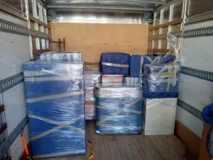 Furniture blanket-wrapped and shrink-wrapped inside a One Stop moving truck