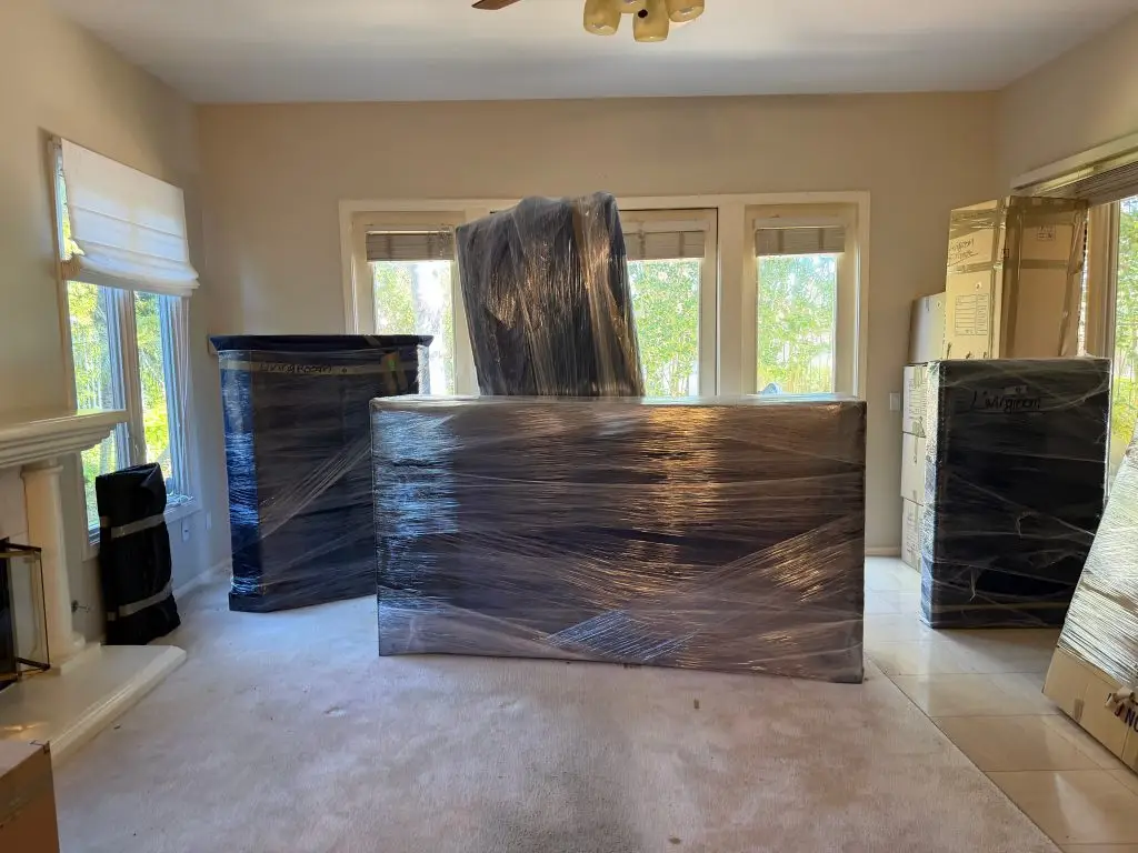 Furniture shrink-wrapped and padded in a San Diego living room before loading