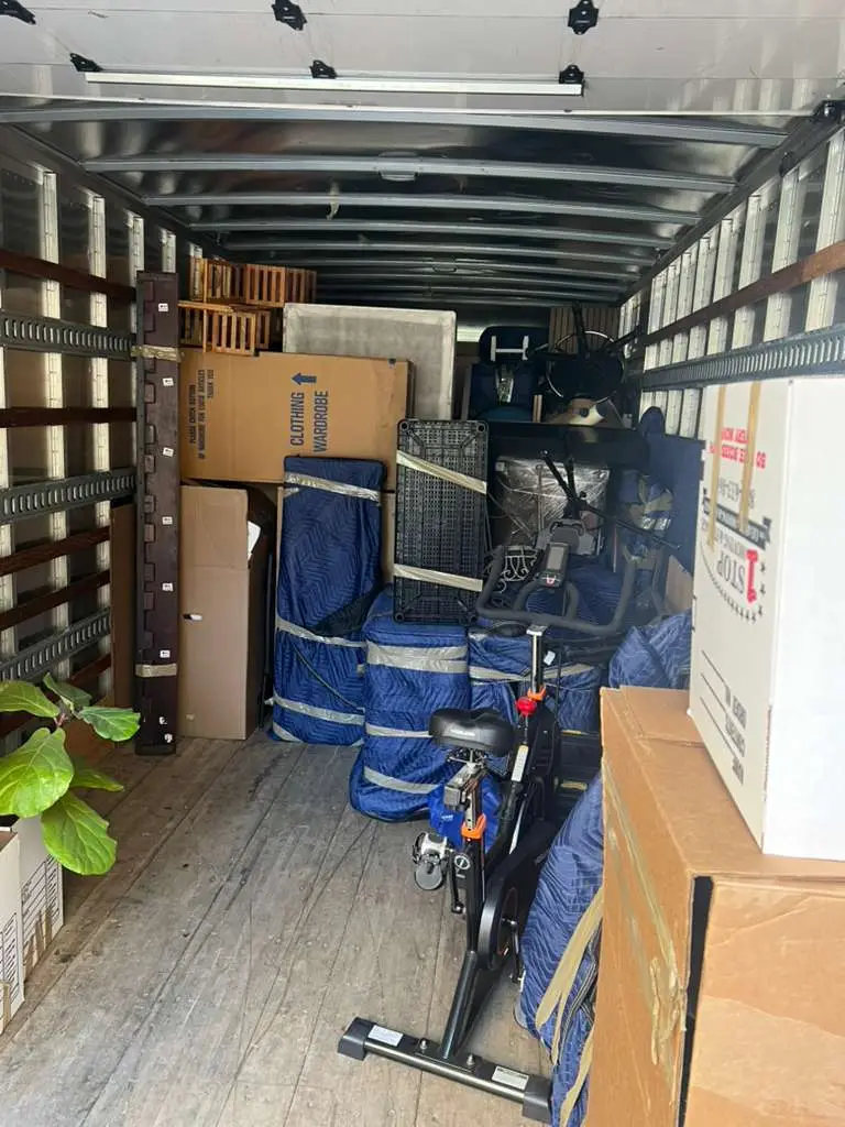 Inside a One Stop truck: boxes and blanket-wrapped furniture loaded for a long-distance move