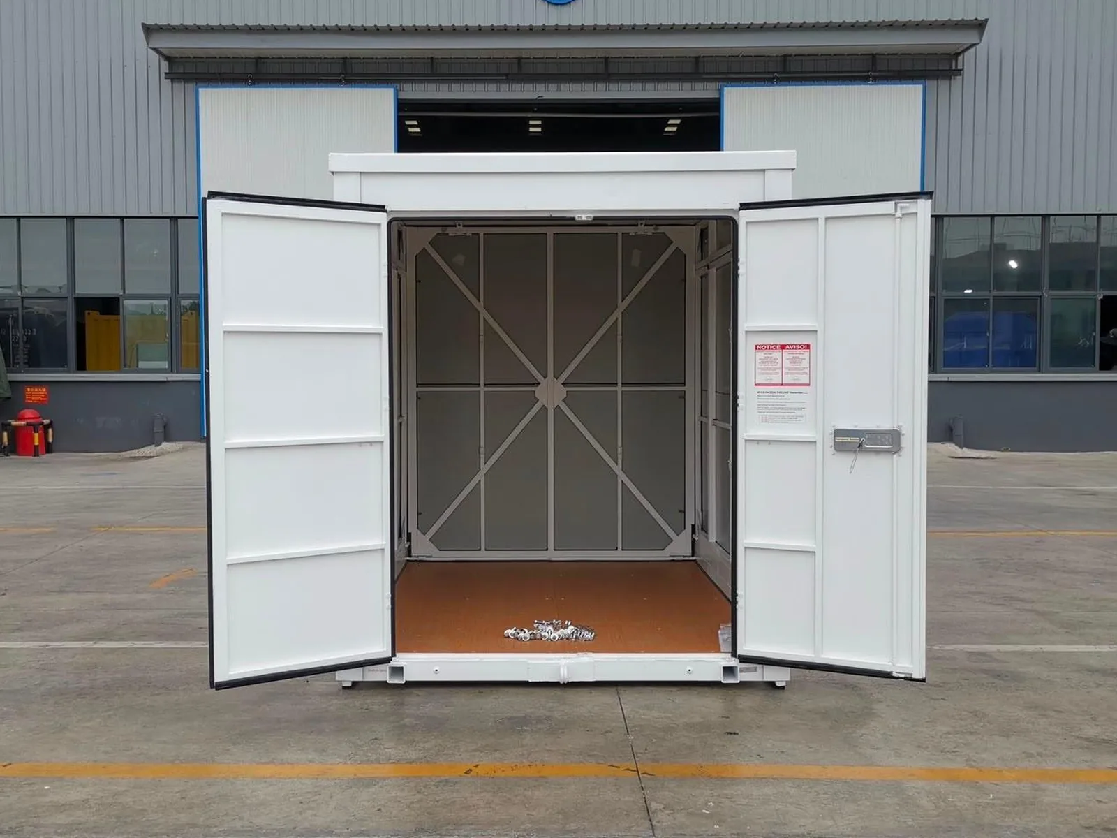 A 1-Box container photographed head-on with both doors swung wide open, showing the empty interior: a wooden floor and braced steel walls.